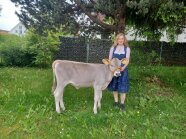 Person und Kalb auf einer Wiese